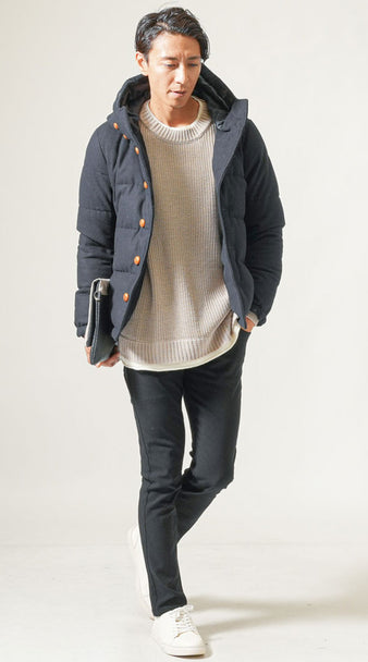メンズの冬コーデ 黒スキニーパンツにベージュニットとネイビーダウンジャケットを合わせ白スニーカーで抜け感を出した着こなし