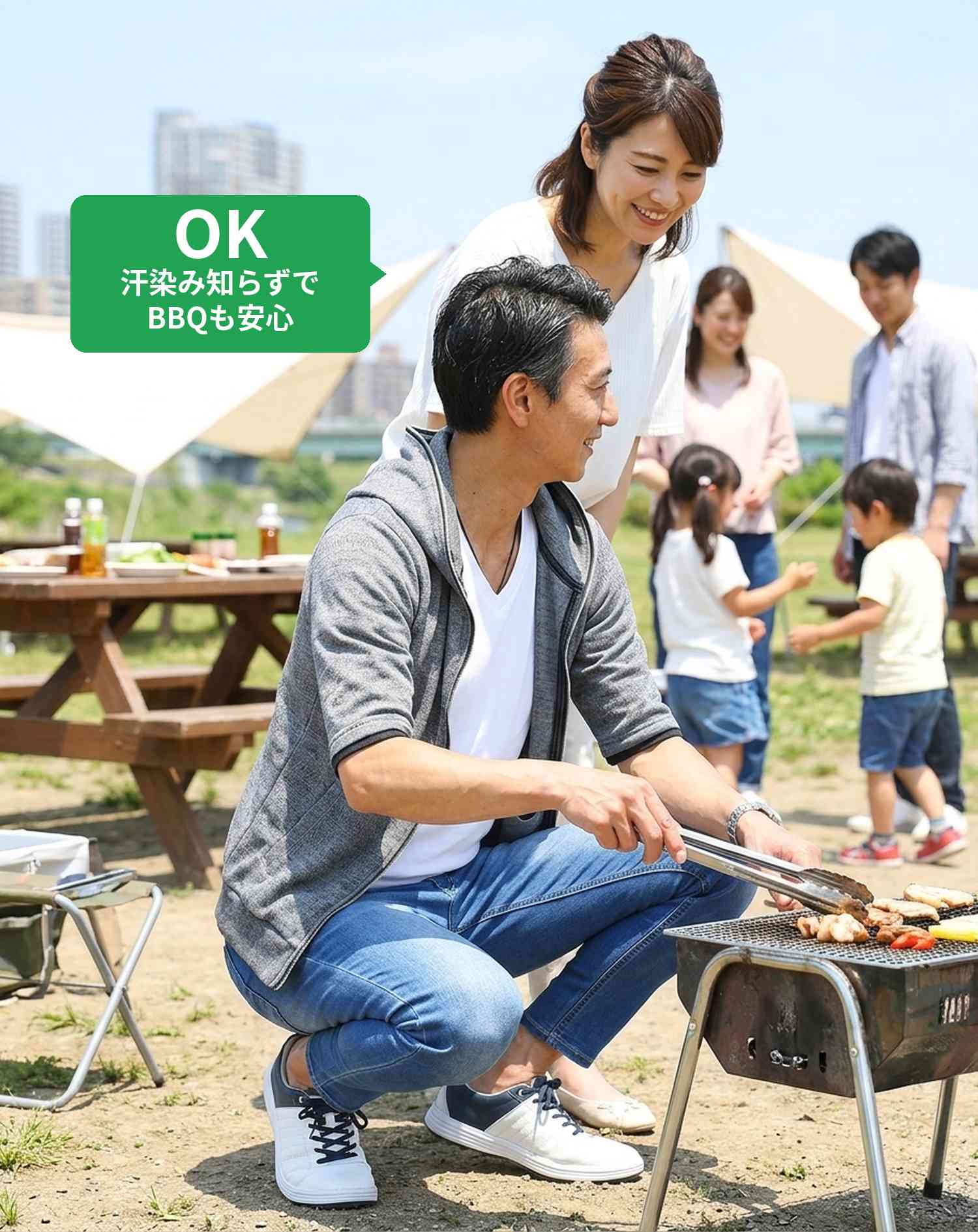 OKコーデ　河川敷・公園のBBQ施設でしゃがんでグリルの様子を見るシーン（OKマーク付き）