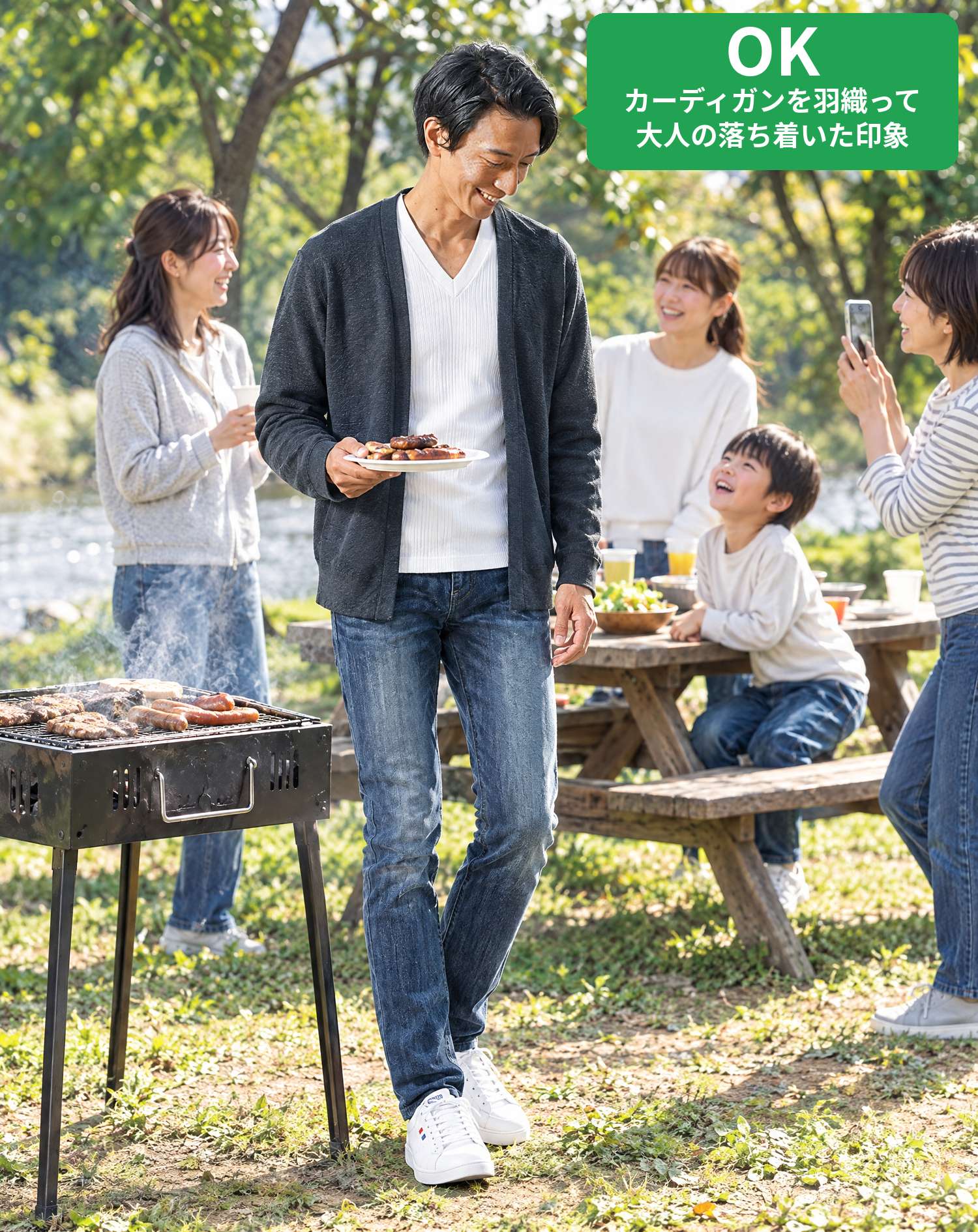 OKコーデ　河原のバーベキュー場で、焼き上がったソーセージを皿にのせて運びながら、ママにスマホで撮られ子供に笑顔で見上げられるシーン（OKマーク付き）