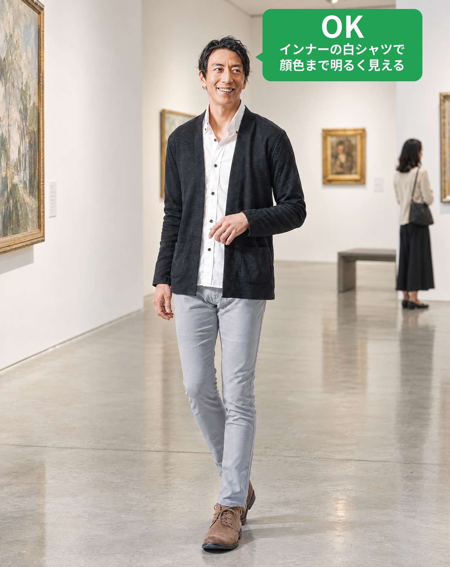 OKコーデ　白い壁の美術館の展示室で、絵画を眺めながら歩くシーン（OKマーク付き）