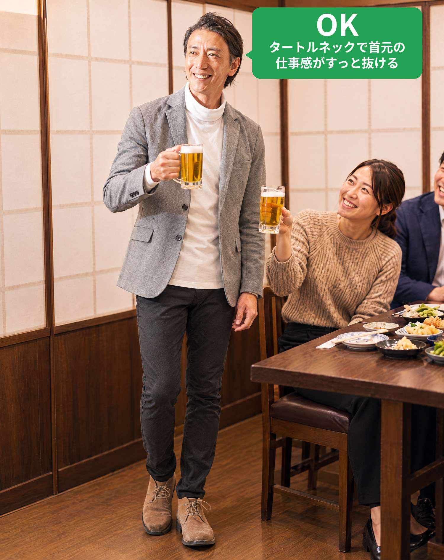 OKコーデ　居酒屋の個室でビールジョッキを掲げ、同僚から笑顔で乾杯されるシーン（OKマーク付き）