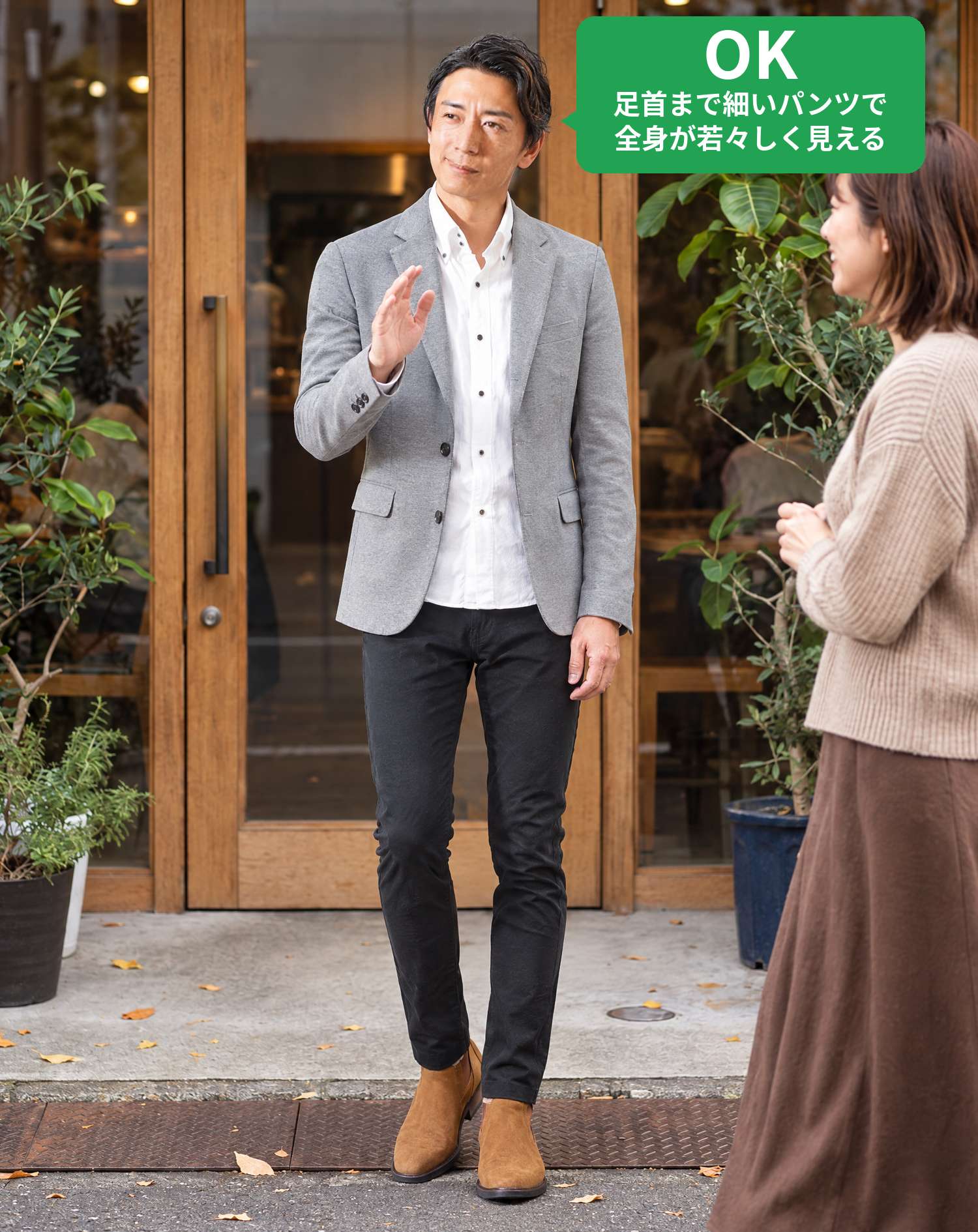 OKコーデ　おしゃれなカフェの前で、お見合い相手の女性に笑顔で手を挙げてあいさつするシーン（OKマーク付き）