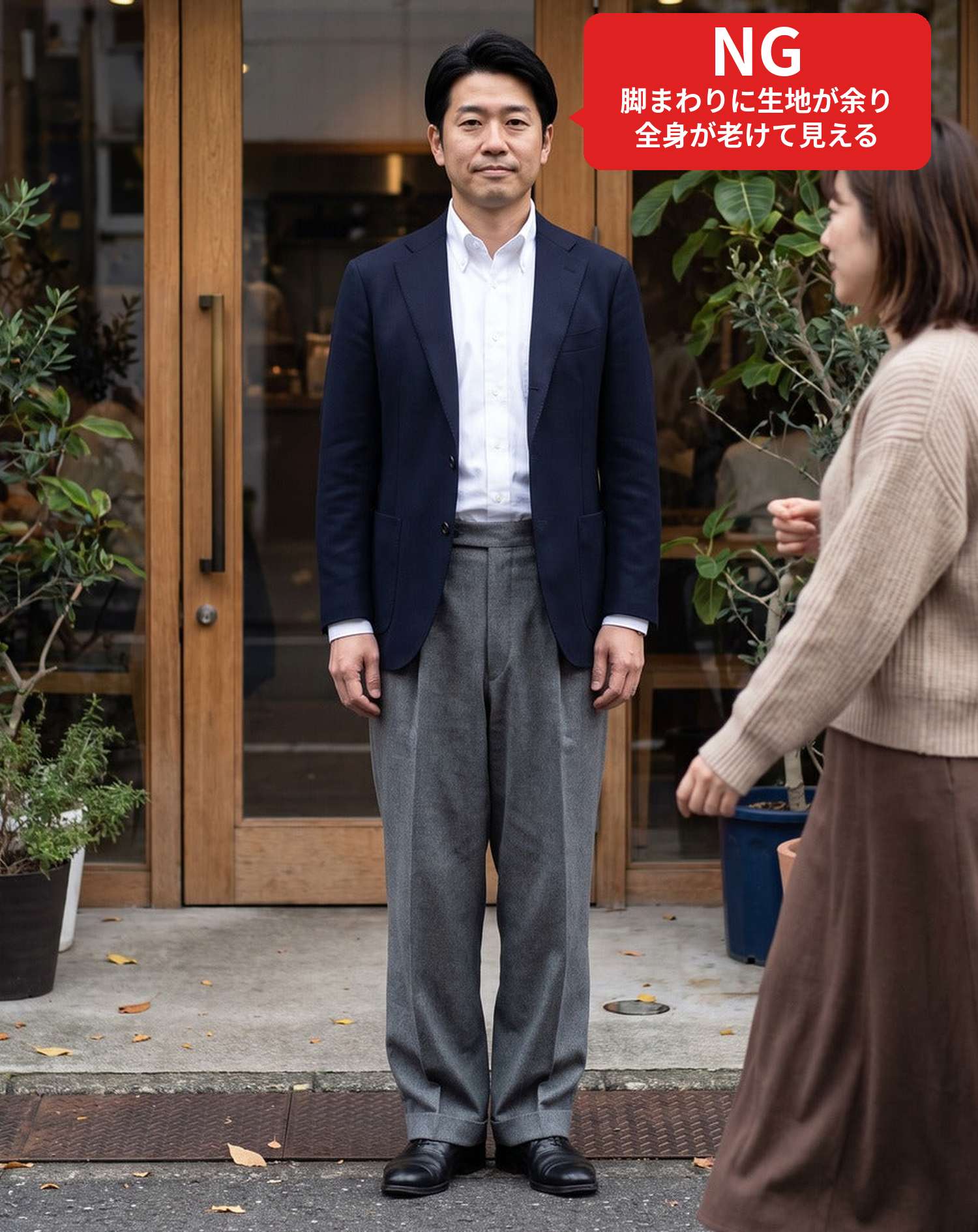 NGコーデ・よくある失敗例　カフェの前で、ジャケットにグレーのゆったりしたスラックスを合わせて立つ状態（NGマーク付き）