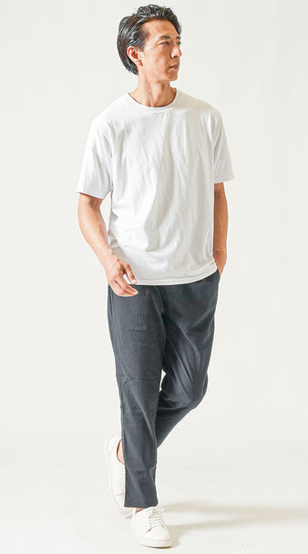 白Tシャツと黒のアンクルパンツを合わせた、夏の黒パンツコーデ メンズのミニマルな着こなし例。