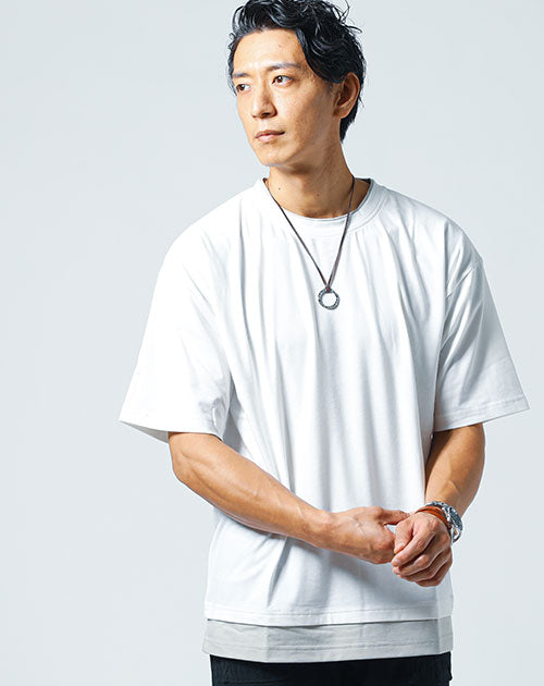 フェイクレイヤード仕様の白Tシャツを着た男性がクールな表情で立っている白Tシャツコーデ