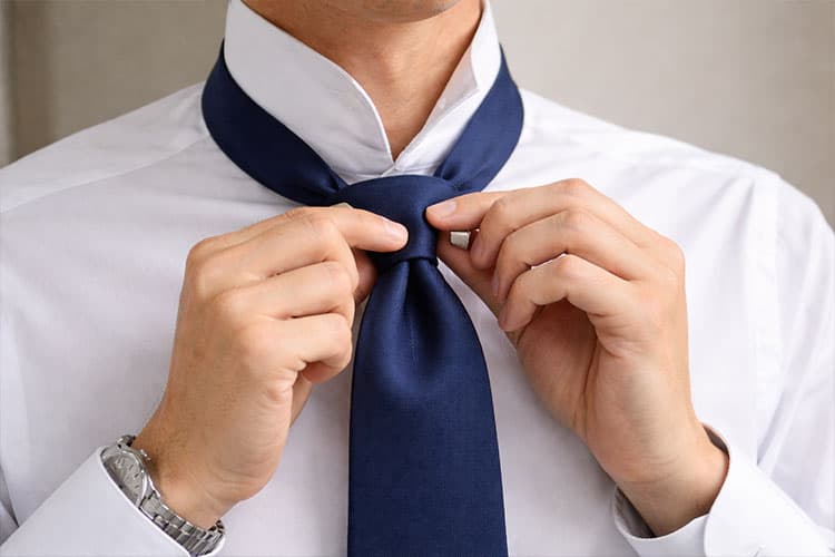 ディンプルを作るために、結び目を締める前に指で軽くくぼみを作っている様子