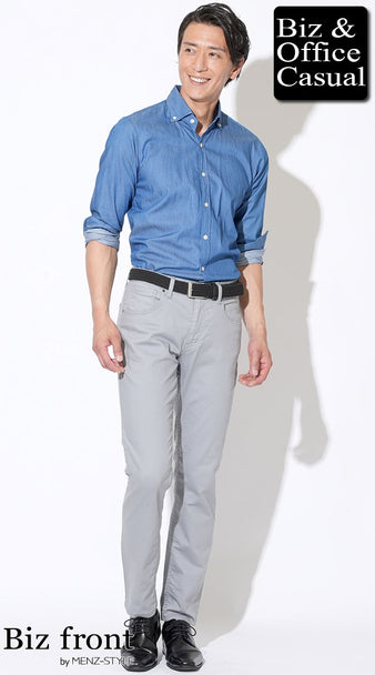 青いシャツをグレーのスリムパンツにタックインし、黒ベルトと黒シューズを合わせたビジネスカジュアルコーデ。