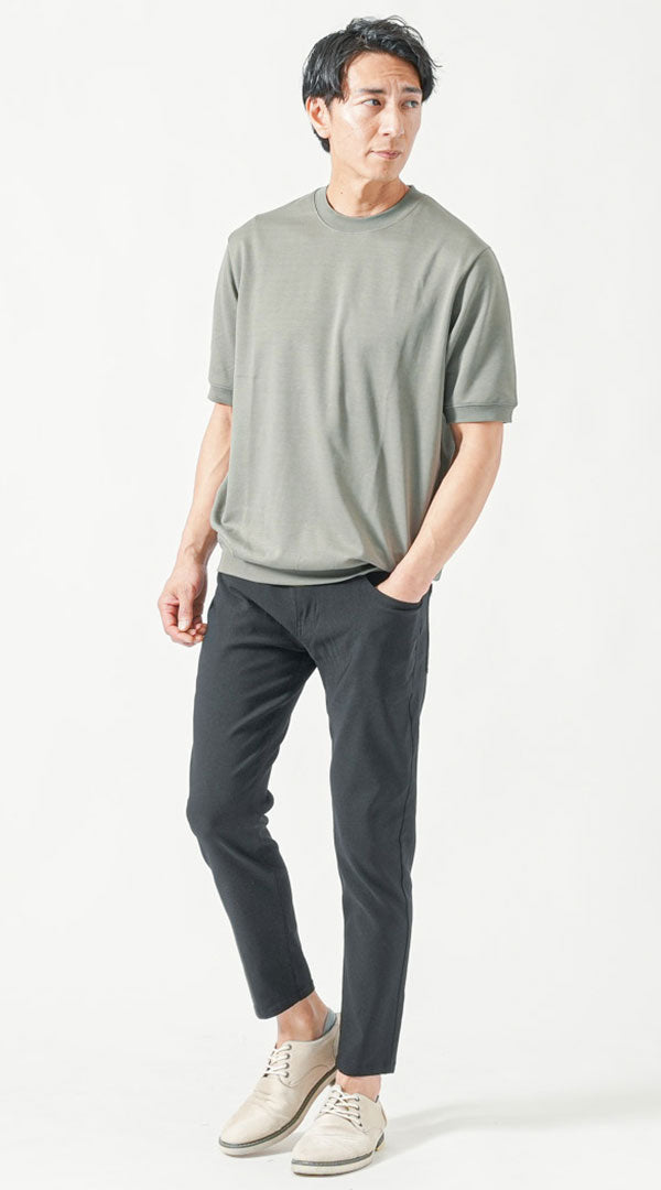 スモーキーグリーンのTシャツと黒のアンクルパンツを合わせた、涼しげな夏の黒パンツメンズコーデ