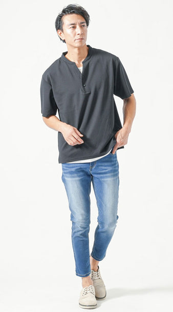 メンズの夏デート服として、黒のヘンリーネックオーバーサイズTシャツに白タンクトップをレイヤードし、ライトブルーデニムを合わせた清潔感あるカジュアルスタイル