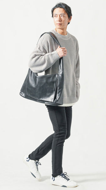 メンズにおすすめの1泊旅行コーデ・グレーニットと黒スキニーパンツにレザーショルダーバッグを合わせたカジュアルな着こなし