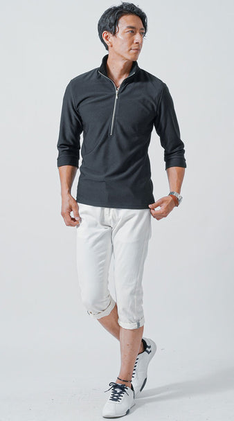 黒ジップポロシャツにクロップド白パンツを合わせたアクティブな夏コーデの男性