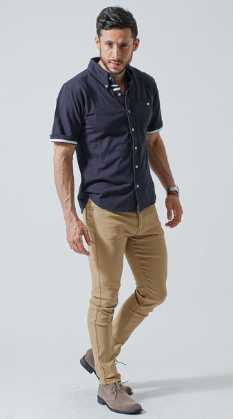 ネイビーポロシャツにスリムなベージュパンツを合わせたシンプルで洗練されたコーディネート