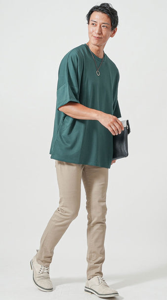 グリーンのオーバーサイズTシャツとベージュスキニーパンツの40代男性向け夏の落ち着きコーデ