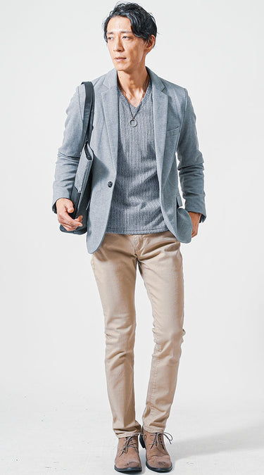 グレー色のテーラードジャケットにグレー色のTシャツとベージュ色のテーパードチノパンのコーデ