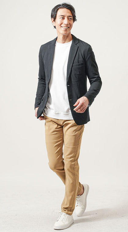 黒ジャケットとベージュパンツに白スニーカーを合わせた季節感のあるビジネスカジュアルコーデ