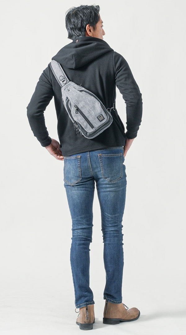 雨の日コーデに最適な防水性の高いグレーボディバッグを斜めがけした後ろ姿の男性