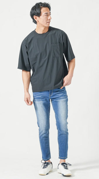 黒のオーバーサイズTシャツに明るめスリムジーンズを合わせた、縦ラインが強調された体型カバーコーデ