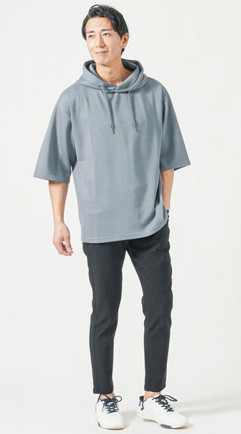 ブルーの5分袖プルオーバーパーカーと黒のテーパードパンツを合わせた、体型カバーと抜け感を両立したメンズカジュアルコーデ
