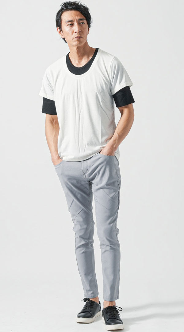モノトーンのフェイクレイヤード白Tシャツにグレースキニーパンツと黒レザースニーカーを合わせたシンプルなメンズ白Tシャツコーデ