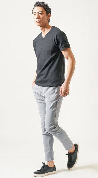 40代男性の夏の飲み会向けコーデ ブラックVネックTシャツにライトグレーパンツと黒レザースニーカーを合わせたテラス席に似合う都会的スタイル