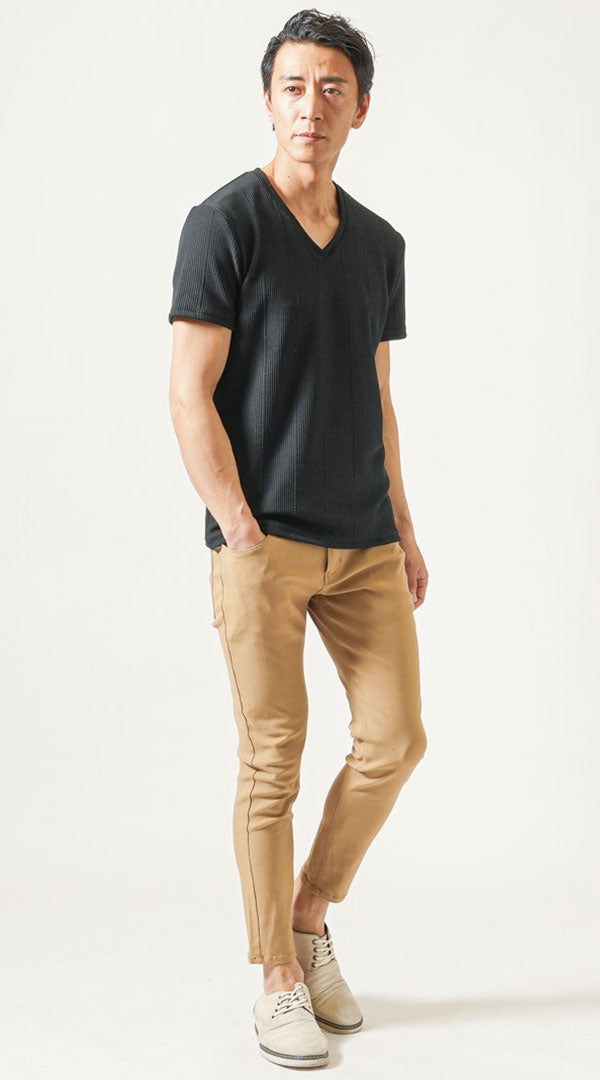 黒の編地VネックTシャツとキャメルパンツを合わせた、立体感と高級感を意識した大人の夏コーディネート