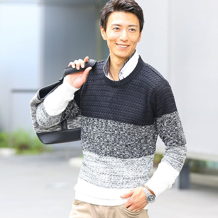 クルーネックニットの下にシャツを着た重ね着コーディネート