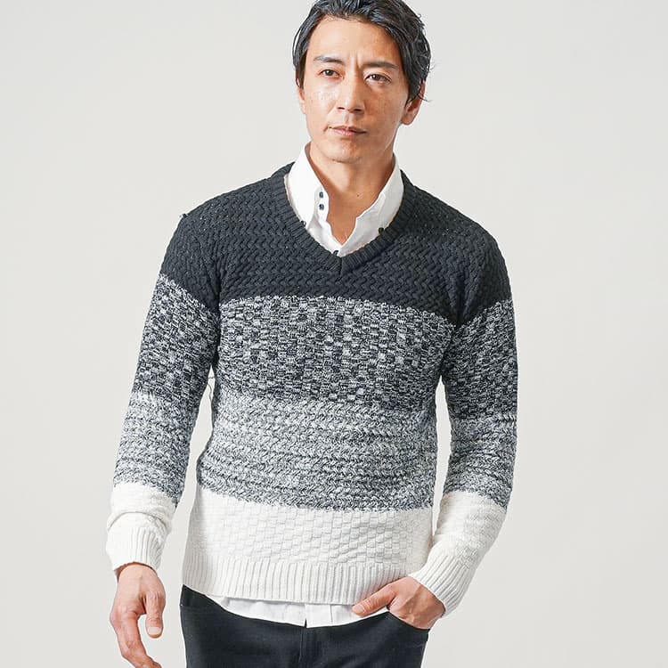 Vネックニットの下にシャツを着た重ね着コーディネート