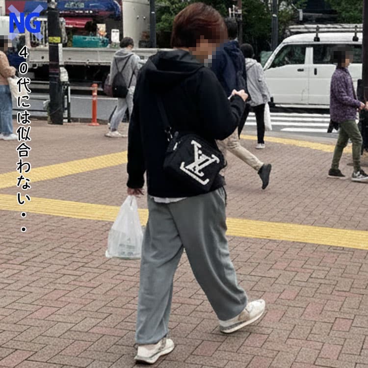 40代メンズが避けるべきブランドロゴが大きく入ったショルダーバッグをもったコーデ例