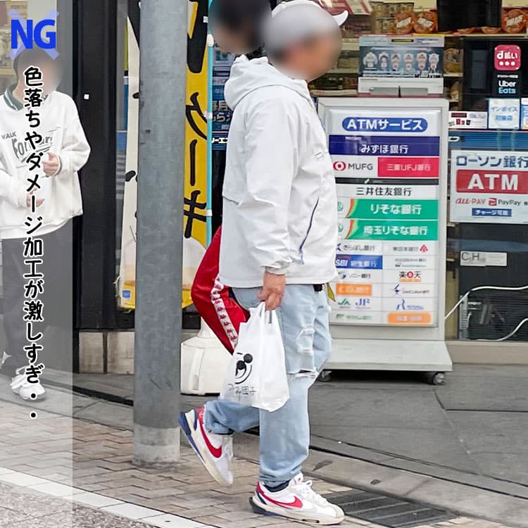 黒のパーカーに色落ち加工が激しいデニムパンツを合わせたコーデ例