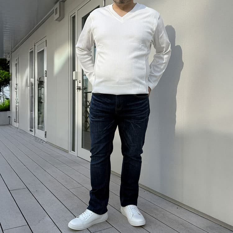 メンズスタイルのスニーカーを着用