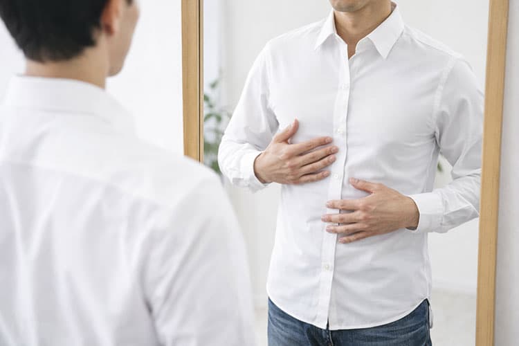 服のサイズのフィット感を確認している男性