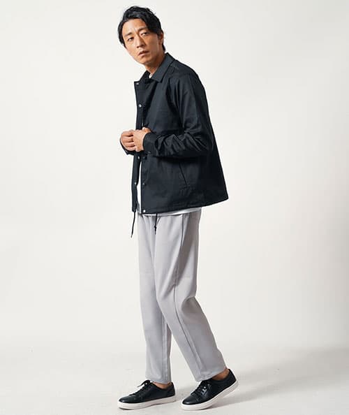 ライトグレーのワイドパンツをはいた男性