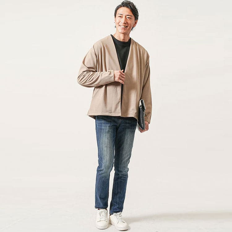 黒Tシャツにベージュジャケットとデニムパンツを合わせたコーディネート