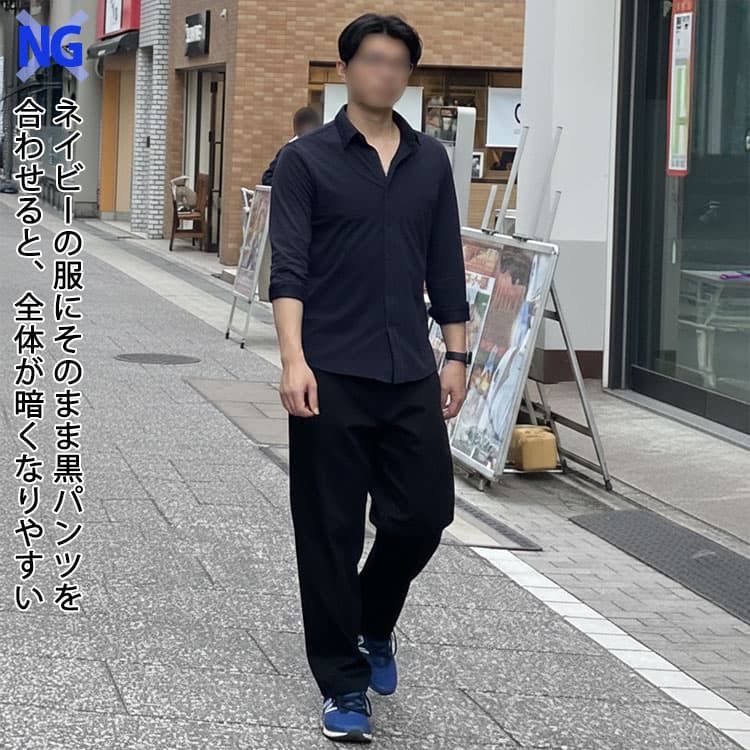 ネイビーの服にそのまま黒パンツを合わせると、全体が暗くなりやすい例