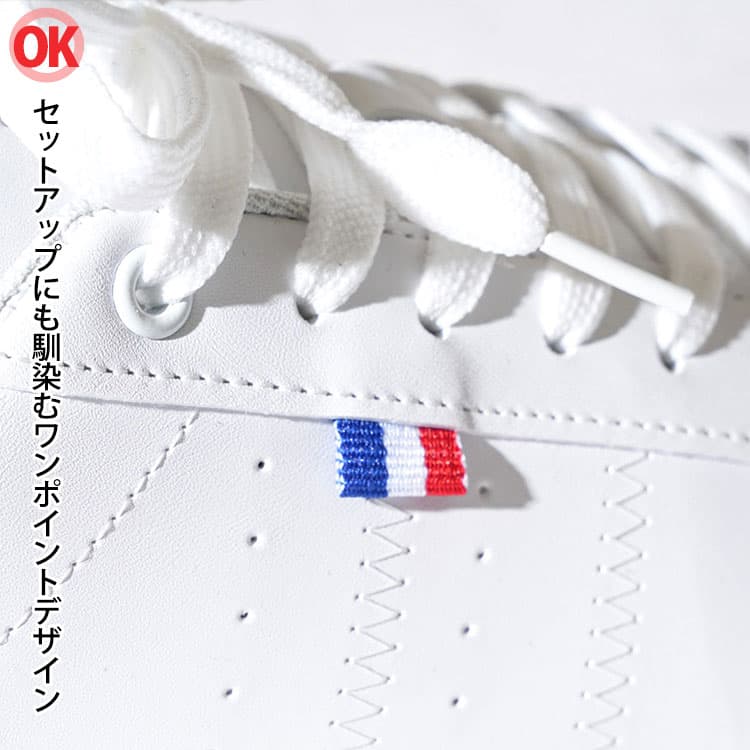 ネイビーのセットアップに合うワンポイントデザインの白スニーカーの画像