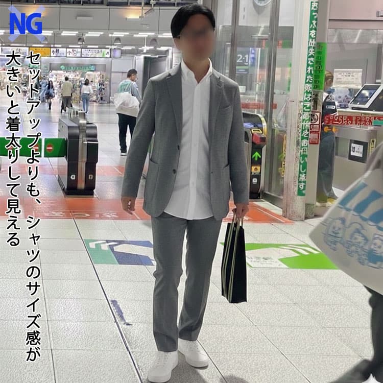 グレーセットアップよりも、シャツのサイズ感が大きくて着太りして見える男性例