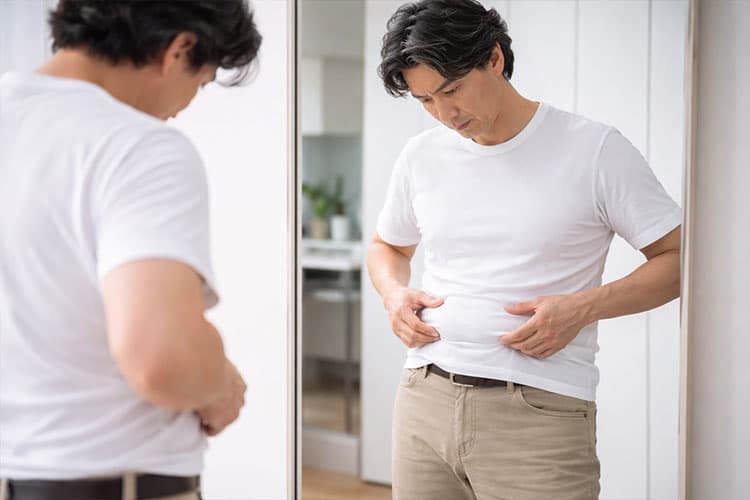 お腹周りを気にしている男性