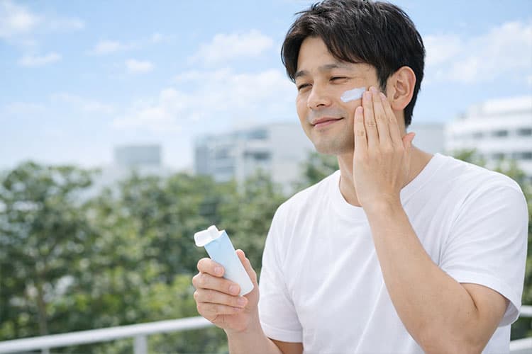 日焼け止めを塗っている男性