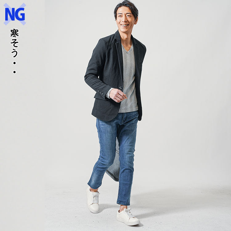 冬に寒いと感じる生地が薄いテーラードジャケットと首回りがあいているインナーを着たNG例