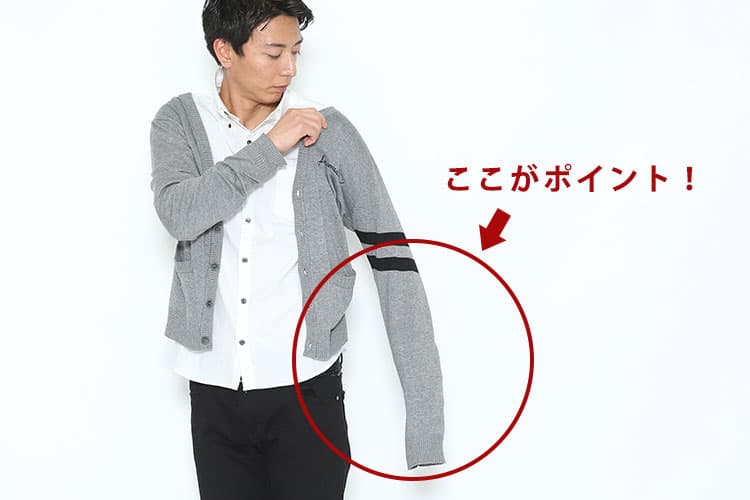 カーディガンの正しい着方①カーディガンを肩で着るように、袖や肩をしっかり通す