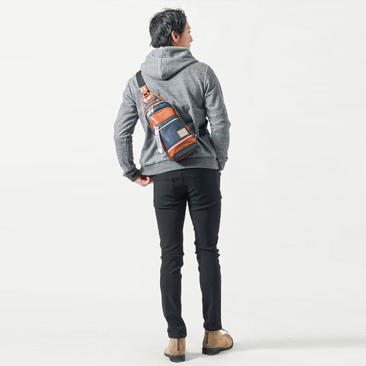 40代メンズがグレーパーカーにブラックパンツ、ブラウンの配色ボディバッグを合わせた大人のカジュアルスタイル