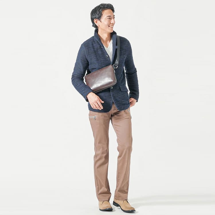 40代メンズ向けネイビー色のイタリアンカラージャケットとブラウンレザーボディバッグの上品コーディネート