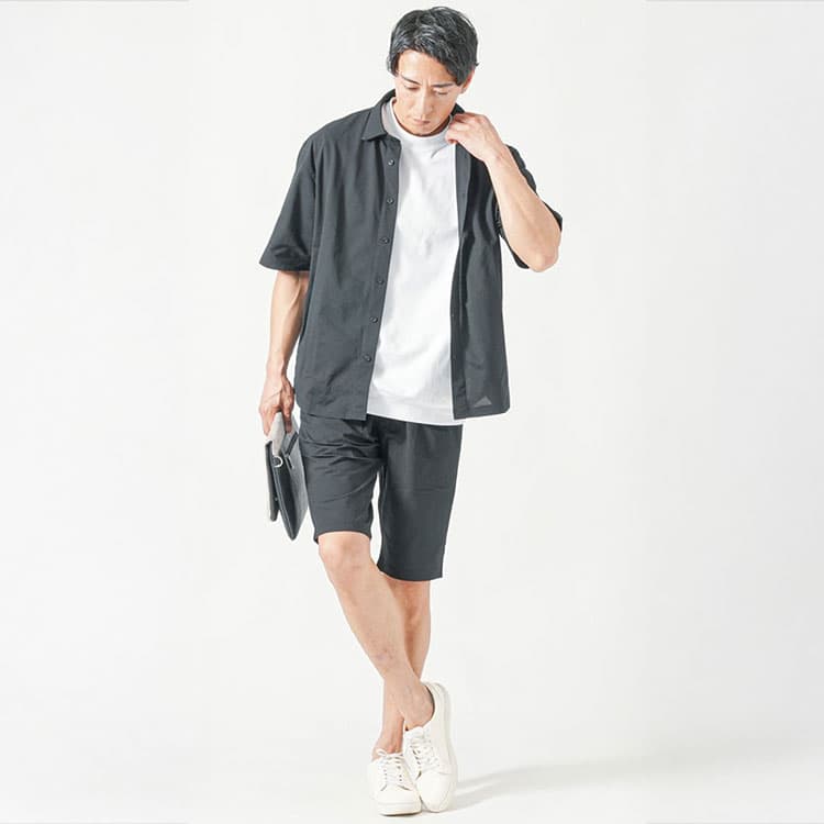40代男性のリラックスカジュアル、白Tシャツと黒の半袖シャツ、ショートパンツでまとめた爽やかコーディネート